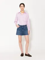 Minifalda de denim azul con calce a la cadera y cinturón fino del mismo material. No tiene bolsillos traseros pero están simulados estampados en blanco.