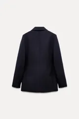 Blazer de lana azul marino con cuello solapa de muescas y manga larga acabada en abertura y botones. Tiene bolsillos con solapa en delantero y de vivo en pecho, forro interior a tono y cierre frontal cruzado con botones.