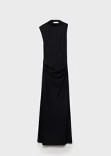 Vestido largo negro de fiesta, con cuello drapeado, sin mangas y abertura lateral. Diseño ajustado con tejido elástico y cintura drapeada.