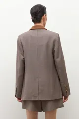 Blazer cruzado de tweed con estampado pata de gallo en tonos marrones y beige. Presenta cuello y detalles en bolsillos en simil gamuza color camel.