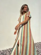 Vestido largo de tejido de punto con rayas verticales multicolores y abertura frontal.