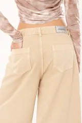 Bermuda de jean color beige, tiro medio, con bolsillos delanteros y traseros.