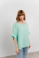 Blusa color beige confeccionada en lino, de corte holgado, mangas 3/4 y cuello redondo.