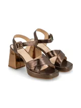 Sandalias de cuero color canela con plataforma y tacón ancho. Tiras cruzadas en el empeine y pulsera ajustable con hebilla en el tobillo.