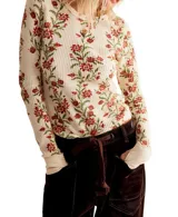 Blusa térmica color crema con estampado floral en tonos rojos y verdes, de mangas largas con puños acampanados.