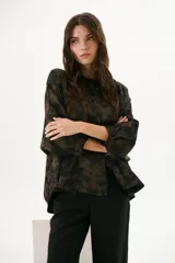 Camisa marrón chocolate con estampado abstracto, cuello mao, mangas 3/4 con puños y cierre frontal con botones.