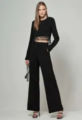 Blusa cropped negra de manga larga con detalle de bordado con flecos plateados en el ruedo.