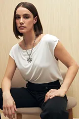 Remera negra de modal con cuello bote y mangas cortas con frunces.