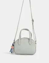 Cartera bowling color gris claro de cuerina con doble asa corta de mano, correa regulable y cierre superior.