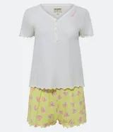 Pijama corto de algodón con blusa blanca de cuello V con botones y mangas cortas onduladas, y short amarillo con estampado de corazones y cintura elástica.
