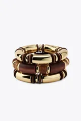 Set de tres pulseras elásticas con cuentas cilíndricas de madera marrón y cuentas metálicas doradas.