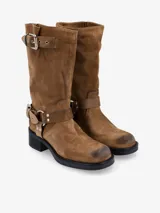 Bota de caña media de cuero negro, estilo biker, con caña arrugada y detalles de correas con hebillas metálicas plateadas en la parte superior y alrededor del tobillo. Posee un taco bajo y grueso.