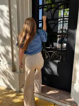 Pantalón sastrero color beige de lino, corte recto y tiro alto, con bordado de caballo en el bolsillo trasero.