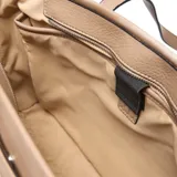 Cartera tipo tote bag de mujer, color taupe, con textura de cuero granulado. Presenta asas largas fijas y herrajes metálicos color níquel. Incluye un logo XL aplicado en el frente.
