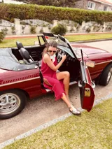 Vestido de fiesta fucsia con escote y espalda de cuero, tajos laterales con hilo metálico y terminación con flecos.