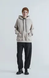 Hoodie color arena de frisa premium, con capucha gigante ajustable y puños elastizados.