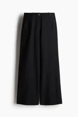 Pantalón negro de lino, de tiro alto, corte ancho y bolsillos laterales.