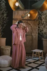 Camisa blanca de lino con bordados dorados de árboles, corte recto, cuello camisero y mangas largas con puños abotonados.