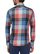Camisa de manga larga a cuadros en tonos azul, rojo, marrón y blanco. Tiene cuello abotonado, bolsillo en el pecho y logo bordado en rojo.