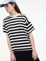 Camiseta boxy de manga corta a rayas horizontales blancas y negras, con cuello redondo.