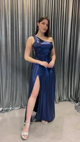 Vestido largo de fiesta azul marino brillante, con un solo hombro y abertura lateral en la falda.