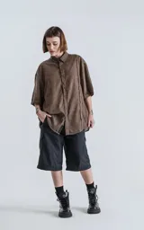 Camisa marrón de mangas cortas, corte holgado y cuello clásico.