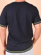 Remera negra con estampado gráfico frontal y detalles en contraste en las mangas.
