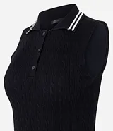 Top de punto sin mangas color negro, ajustado al cuerpo, con cuello polo que presenta ribetes blancos contrastantes. Tiene un cierre frontal de tres botones y un ribete blanco en el ruedo inferior.