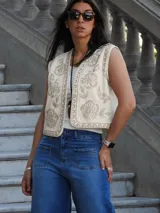 Chaleco color natural con bordados de flores en hilo color beige.