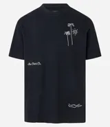 Remera color crema de corte holgado con cuello redondo y mangas cortas. Presenta un pequeño bordado en el frente con diseño de palmeras y sol.