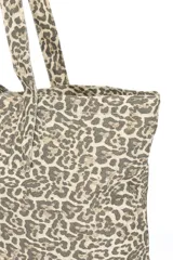 Bolso shopper con estampado animal print en tonos beige y marrón. Tiene doble asa de hombro y cierre superior.