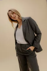 Blazer blanco de corte entallado, con solapas, cierre de un botón y bolsillos con tapa. Confeccionado en tela de sastrería noble.