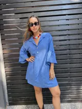 Minivestido celeste con bordado inglés, cuello camisero, mangas 3/4 acampanadas y cierre frontal con botones.