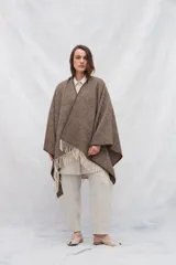Ruana marrón con flecos blancos en el borde inferior.