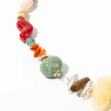 Collar corto con cadena dorada y cuentas de diferentes formas y colores: celeste, naranja, verde, amarillo, marrón, rojo, blanco y rosa.