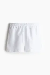 Short de baño blanco de tela con tajos laterales cortos. Elástico revestido con cordón para ajustar en la cintura, bolsillos laterales y bolsillo atrás con cierre autoadherente. Suspensor interior de malla.