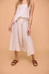 Pollera midi color beige de lino, con cintura ajustable con botón y bolsillo cargo en el lateral.