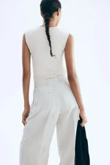 Top sin mangas en microfibra color crudo. Modelo ajustado con leve escote cuadrado y bajo recto. Parcialmente forrado.