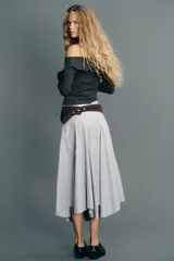 Falda midi de tiro medio con estampado de rayas verticales azules y blancas. Presenta costura de cintura asimétrica, detalle de pliegues y cierre lateral con cremallera oculta.