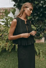 Conjunto de top sin mangas con lazos en el escote y falda midi de lino color negro.