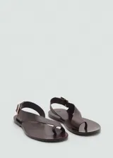 Sandalias negras de cuero con tira cruzada y hebilla dorada.
