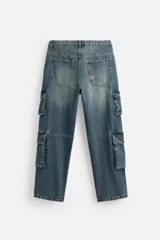 Pantalón cargo de denim color beige, corte relaxed fit, con bolsillos laterales tipo parche con solapa y cierre frontal con botones.