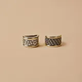 Anillo ancho de plata con diseño trenzado y bordes de oro.