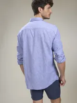 Camisa verde militar de manga larga, confeccionada en mezcla de lino y algodón. Tiene cuello clásico, cierre con botones y un bolsillo en el pecho.