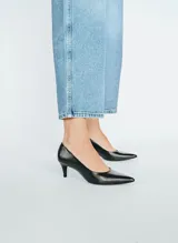 Zapato de tacón color negro, de cuero, con punta fina y tacón kitten heel.