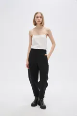 Pantalón blanco de poliéster, corte ancho, tiro alto y bolsillos laterales.
