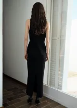 Chaleco negro sin mangas con cuello camisero, botones dorados con diseño de joya y corte entallado.