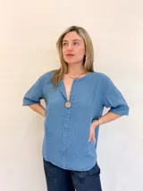 Blusa celeste de lino con escote en V y botón de madera.