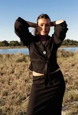 Camisa negra con lazo ajustable en la cintura y mangas abullonadas.