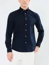 Camisa de popelina azul marino de Tommy Hilfiger, de manga larga, con cuello abotonado, cierre con botones y logo bordado en el pecho.